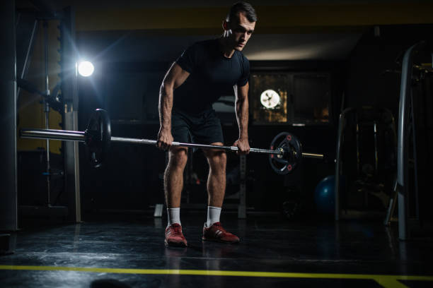 istock Young man lifting heavy weight 1185112656