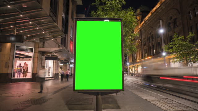 City street Billboard stand with green screen. Time lapse with commuters, people and cars. Space for text or copy.