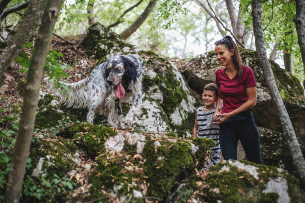 istock Mother with a son and a dog exploring nature 1185114292