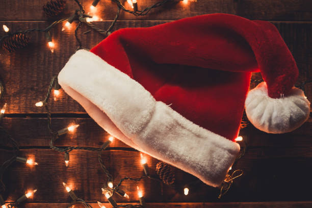 istock Christmas Lights and Santa's hat on dark Wood 1185114377