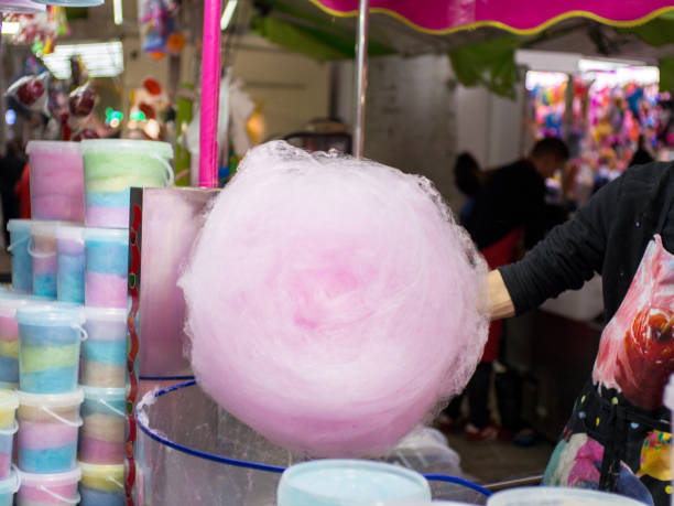 istock Man making cotton candy at funfair stand 1185122009
