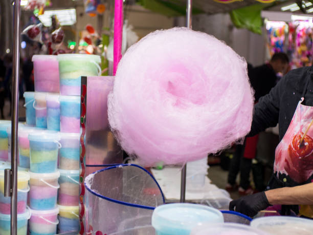 istock Man making cotton candy at funfair stand 1185122010