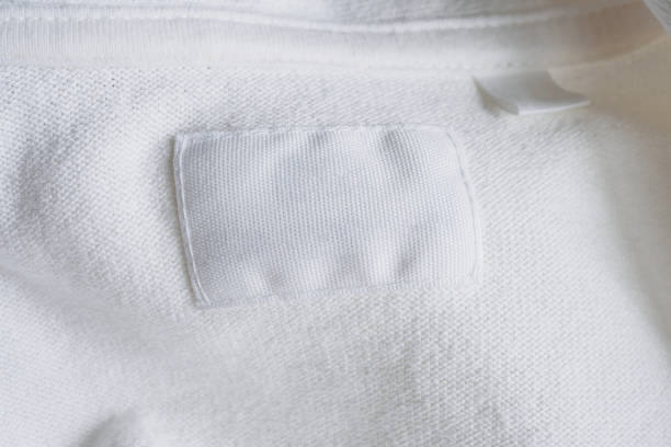 istock Blank white clothes label on new cotton shirt background 1185122116