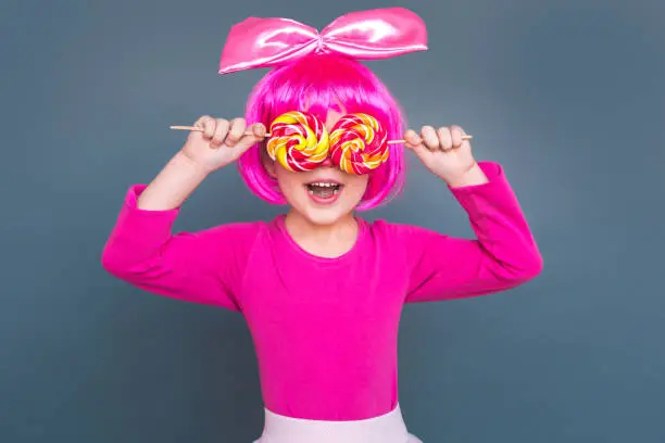 Photo of Girl clown closed eyes two candies and toothy smiling