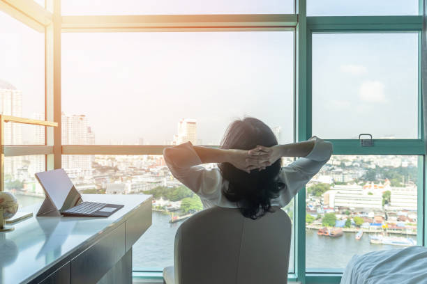 o abrandamento do contrapeso da trabalho-vida com o estilo de vida saudável da mulher de negócio de funcionamento asiática toma o descanso fácil no hotel ou na sala de visitas home do conforto que têm o tempo livre com paz de espírito e contrapeso da - relaxation success luxury women - fotografias e filmes do acervo