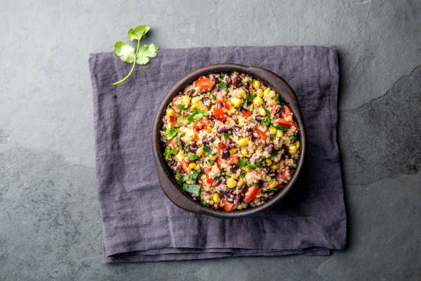 istock Mexican black bean corn quinoa salad in clay bowl top view, copy space 1185122543