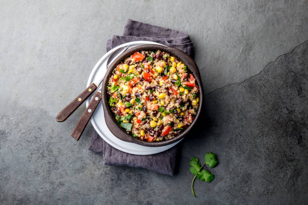 istock Mexican black bean corn quinoa salad in clay bowl top view, copy space 1185122544