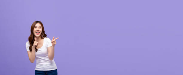 istock Smiling Asian woman pointing hand and looking to copy space aside 1185126053