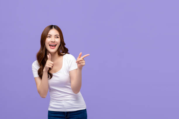 istock Happy young Asian woman with big smile pointing with both hands 1185126058