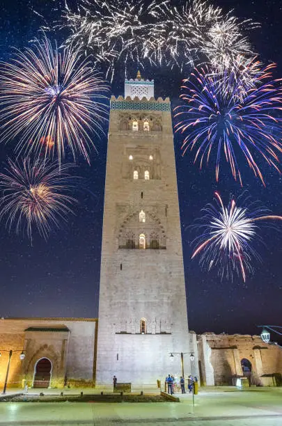 Photo of Koutoubia Mosque minaret in old medina with fireworks in Marrakesh, Morocco