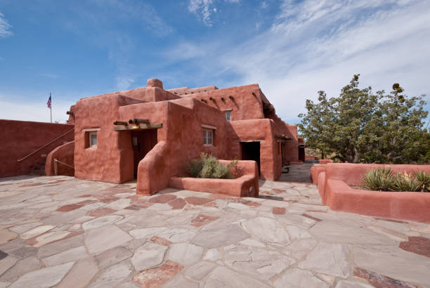 The Painted Desert Inn Holbrook, Arizona, USA - September 24, 2019: In its almost 100 years overlooking the Painted Desert, the inn has undergone many changes. The original structure, built from petrified wood by Herbert David Lore in the early 1920s was operated as a tourist attraction. Visitors could eat meals and the inn had six small rooms to accommodate overnight guests. In the 1930’s the property was purchased by Petrified Forest National Monument and the building was rebuilt by the Civilian Conservation Corp. In 1940 the inn was reopened for meals, souvenirs and lodging. Once again during World War II the inn was closed. After the war, the inn was taken over and operated by the Fred Harvey Company. The company’s famed architect, Mary Colter, redesigned the building to give it a Southwestern look which is maintained today. The building was registered as a national historic landmark in 1987 and now serves only as a museum with no overnight accommodation and food service. The Painted Desert Inn is located on Kachina Point in Petrified Forest National Park near Holbrook, Arizona, USA. jeff goulden petrified forest national park stock pictures, royalty-free photos & images