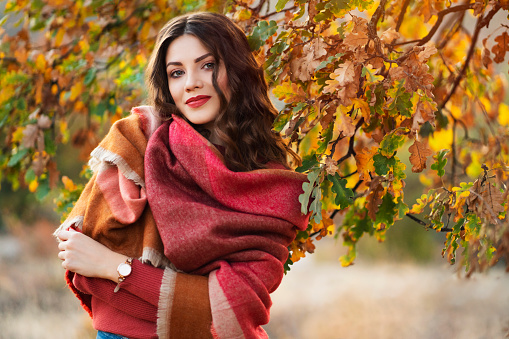 Portrait of a beautiful young caucasian woman enjoying a carefree autumn day in nature.
