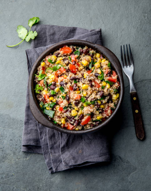 istock Mexican black bean corn quinoa salad in clay bowl top view, copy space 1185128902