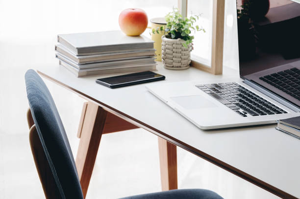 istock Office desk wih laptop blank screen and stack of books. 1185129840