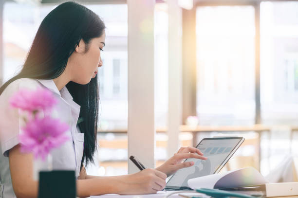 istock Young woman working with laptop while sitting in modern office. 1185129924