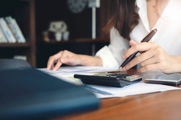 istock Woman using calculator at office desk. 1185130766