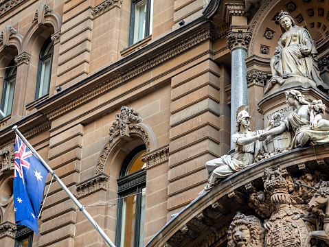 Sydney, Australia - Mar 14, 2018: Sculptured statue of Queen Victoria, the Australian flag, and all the stone architectural designs, at the entrance the General Post Office (GPO) in Martin Place.