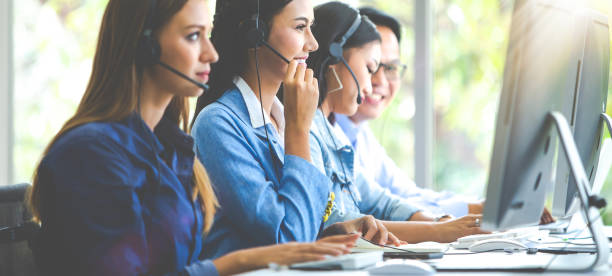 attractive business woman and business man with headsets are smiling while working with computer in office - center occupation headset on the phone imagens e fotografias de stock