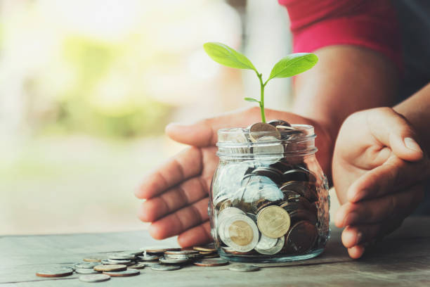 istock hand protection money with tree on jug glass. concept saving 1185141904