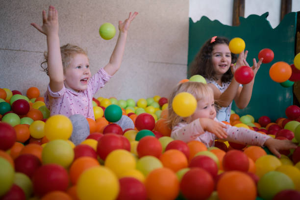 Two young boys playing in a ball pool in kid's playroom.