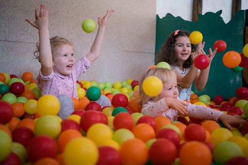 Happy group of kids playing at a ball pool.