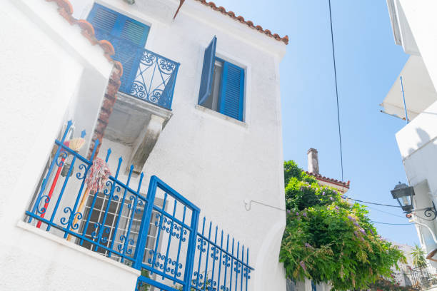 Typical Greek Island whitewashed and blue architecture with broom and mop on cobalt blue wrought iron balustrade.