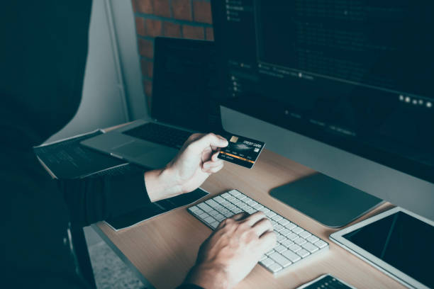 istock Hacker in the hood working with computer and holding credit card with payment hacking concept. 1185167218