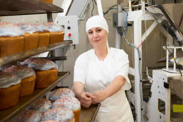 istock Bakery.A bakery worker with produce. Industrial production of Easter cakes. 1185167685