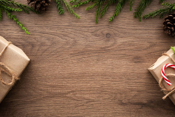 istock Wood table with Christmas decoration including gift boxes, candy cane, pine branches and pine cones. Merry Christmas and happy new year concept. Top view with copy space, flat lay. 1185167697