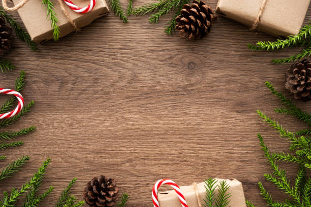 istock Wood table with Christmas decoration including gift boxes, candy cane, pine branches and pine cones. Merry Christmas and happy new year concept. Top view with copy space, flat lay. 1185167726