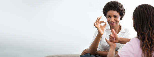istock Woman Teaching Her Friend Hand Sign Language 1185170029
