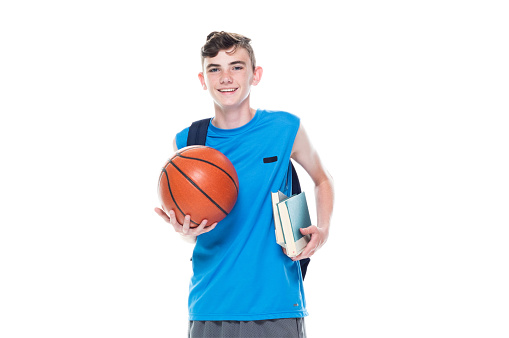 Front view / one man only / one person / full length / one teenage boy only of 12-13 years old handsome people caucasian male / young men basketball player / student / university student / junior high student / boys / teenage boys in front of white background wearing backpack who is learning / studying and holding basketball - ball / book / textbook / bag / using sports ball / basketball - sport / sport / back to school