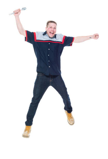 front view / full length / one person of 20-29 years old adult handsome people caucasian young men / male mechanic / auto mechanic / manual worker / repairman jumping in front of white background wearing uniform who is joy / excited / happy / smiling - beautiful men young adult 25 30 years imagens e fotografias de stock