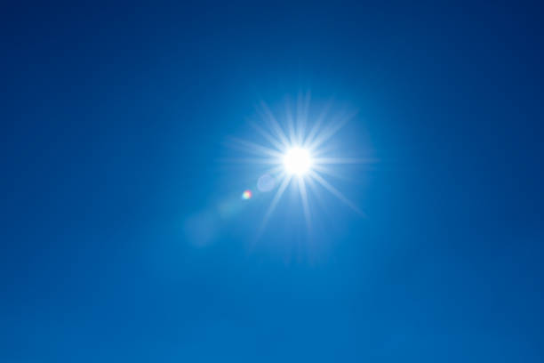 istock Sun, sunbeams against blue sky - cloudless heaven. Photography with Lense flair effect 1185178549
