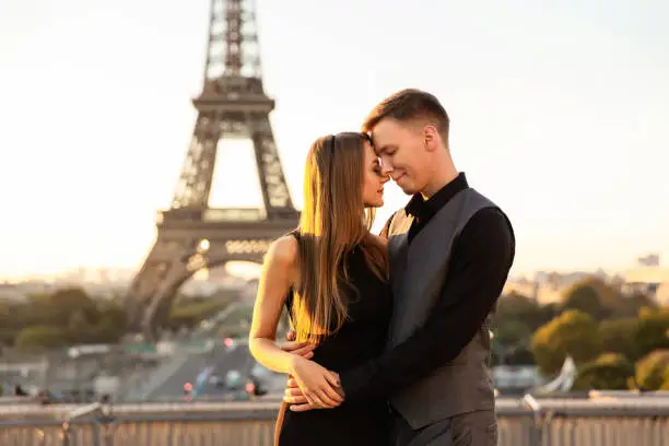 Photo of From Paris with love. Beautiful couple embracing near the Eiffel tower. Romantic date, honeymoon in France