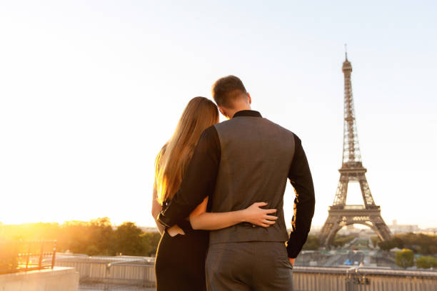 glückliches paar mit blick auf den eiffelturm, romantisches datum in paris. flitterwochen in frankreich - paris france eiffel tower love kissing stock-fotos und bilder