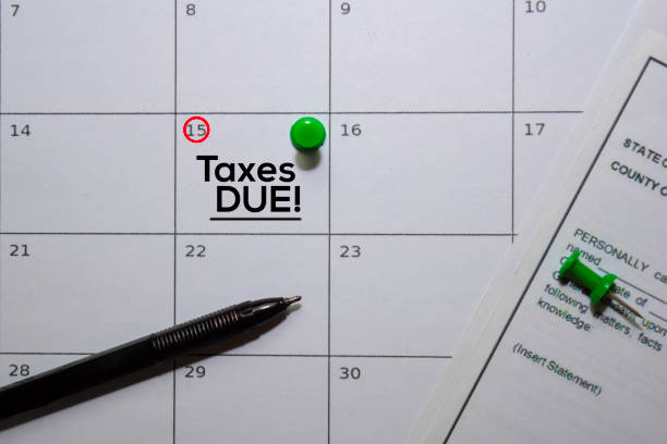 istock Taxes DUE! text on white calendar background. Reminder or schedule concept 1185185156