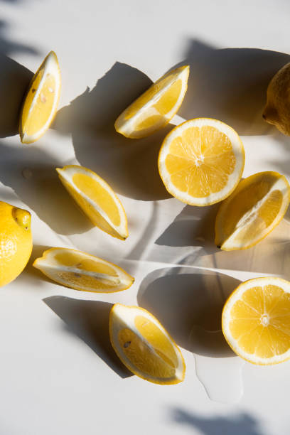 istock Fresh lemon slices on a table with trendy artistic shadows in the morning sunlight. 1185189832