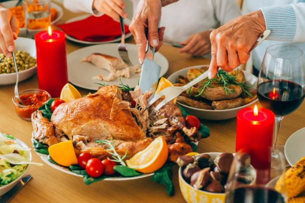 persona irriconoscibile che taglia il tacchino arrosto durante la cena delle vacanze al tavolo da pranzo. - turkey carving portion dinner foto e immagini stock