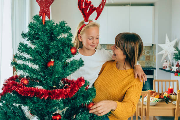 istock Mother and daughter decorate the Christmas tree 1185193191