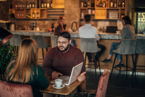 istock Friends working on laptop in cafe 1185194805