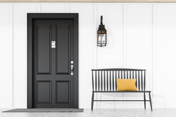 istock Black front door of white house with bench 1185197195