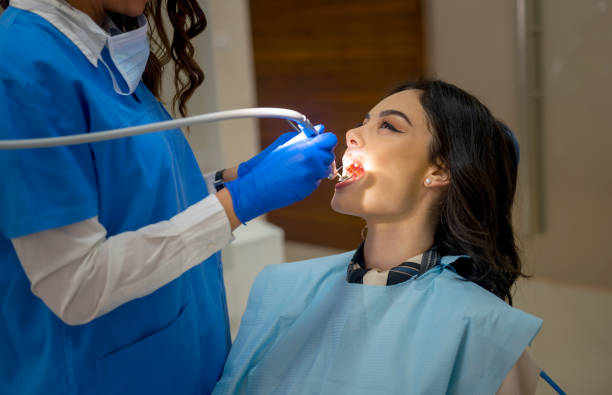 mujer joven en el consultorio de un dentista - mouth open dental drill holding doctor fotografías e imágenes de stock