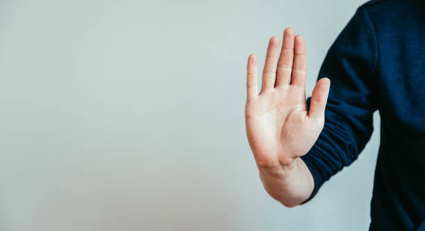 Defense or stop gesture: Male hand with stop gesture stock photo