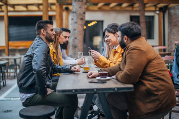 istock Group of young joyful friends having fun in a pub 1185198492