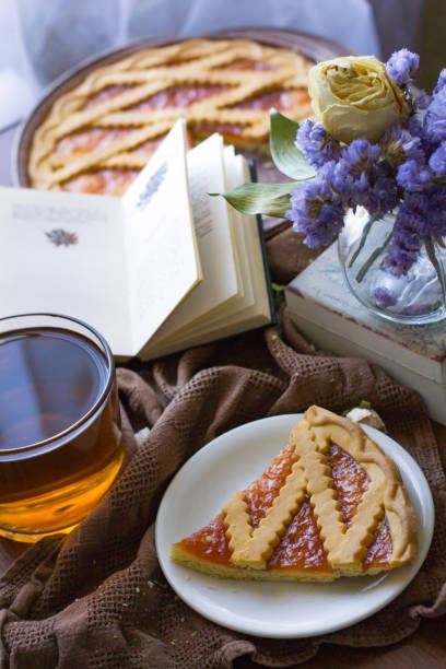istock Bright still life with cup of tea, fruit pie, book and bouquet 1185198544
