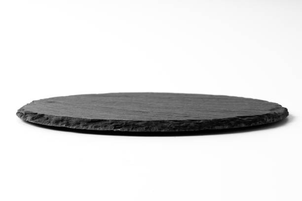 istock Black round stone plate isolated on white background 1185199394