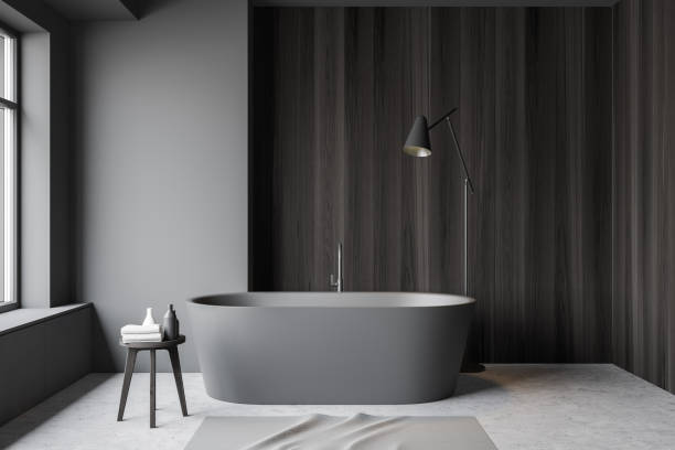 istock Grey and wood bathroom interior, tub and lamp 1185199402