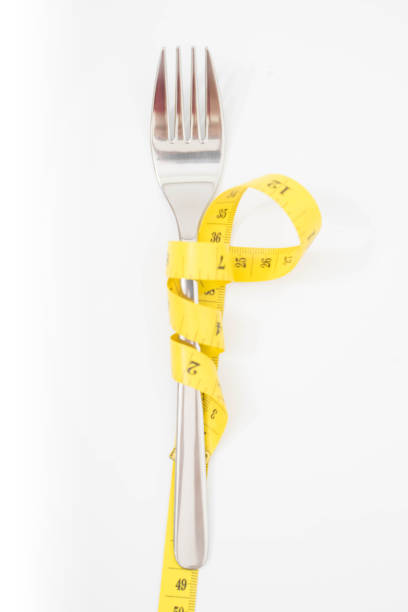 istock fork with a measuring tape diet or healthy eating concept concept 1185199445