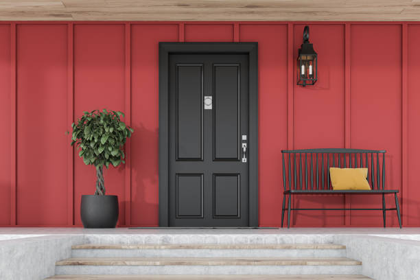 istock Black front door of red house with tree and bench 1185199643